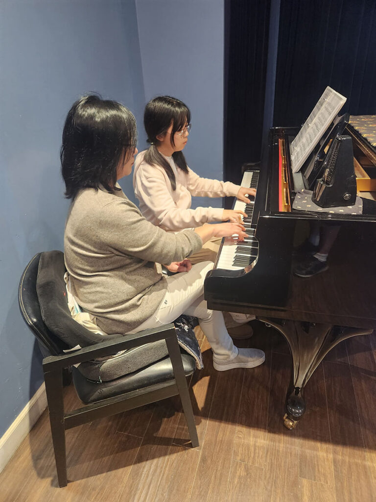 Teacher and student playing piano